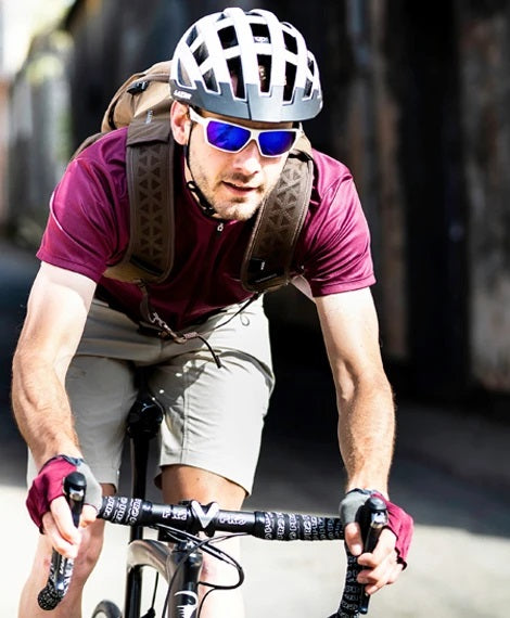 Cyclist wearing maroon, wearing a white Lazer helmet and sunglasses.